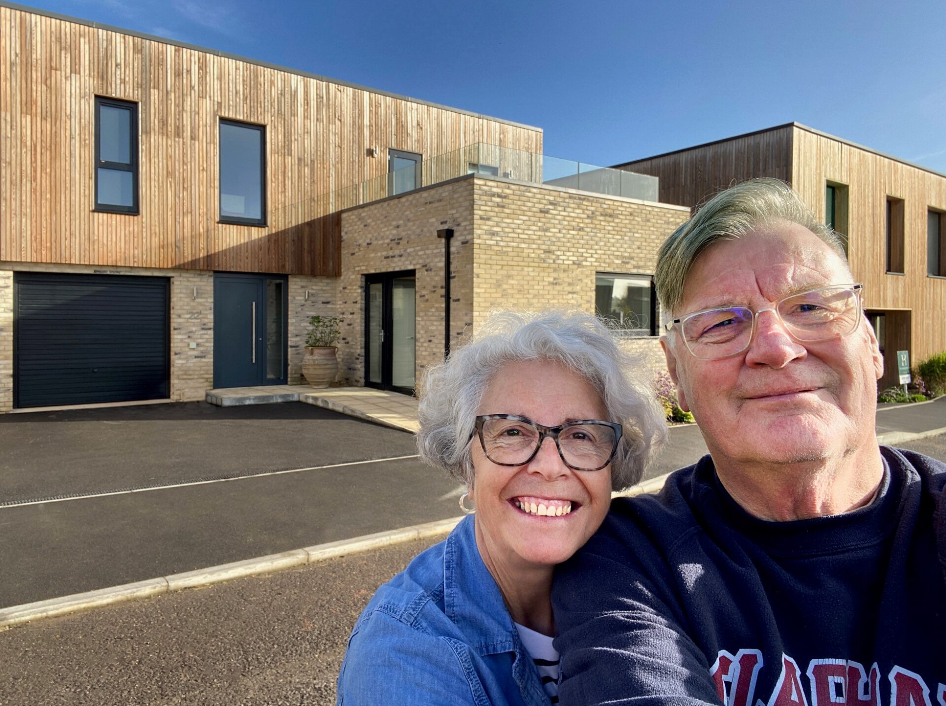 Two happy people outside a property